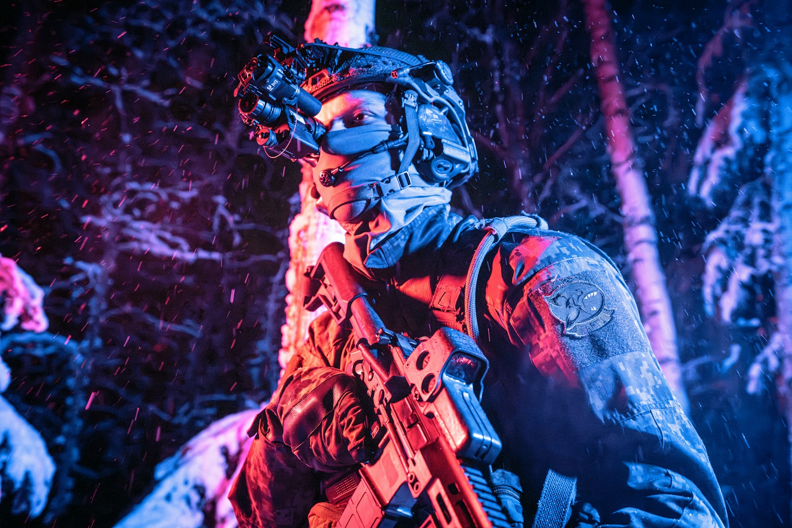 A man with a gun standing in the woods